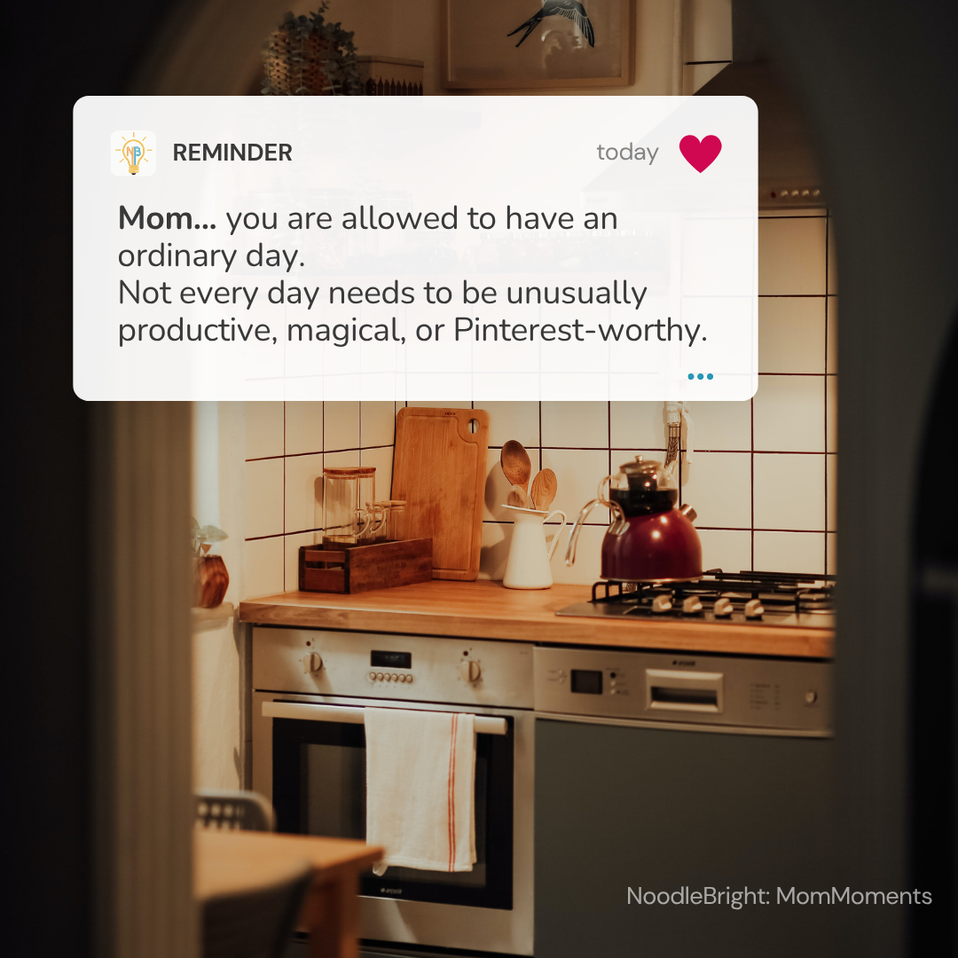 A digital reminder card overlay reading , "Mom... you're allowed to have an ordinary day. Not every day needs to be unusually productive, magical, or Pinterest-worthy." The card is set against an ordinary kitchen backdrop.