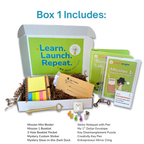Educational entrepreneurship business kit subscription box for kids ages 9-14 with various items including a sticky notepad, key, and books on a white background.