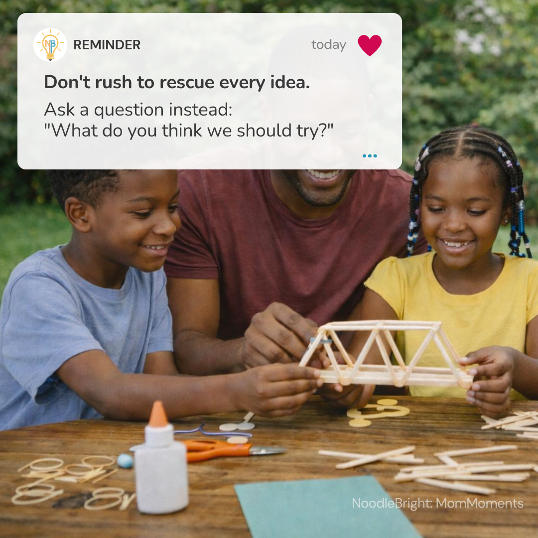 A father and two children are gathered around a wooden table outdoors, building a bridge with wooden sticks, gears, and a bottle of glue. A white reminder card overlay at the top contains positive parenting text.