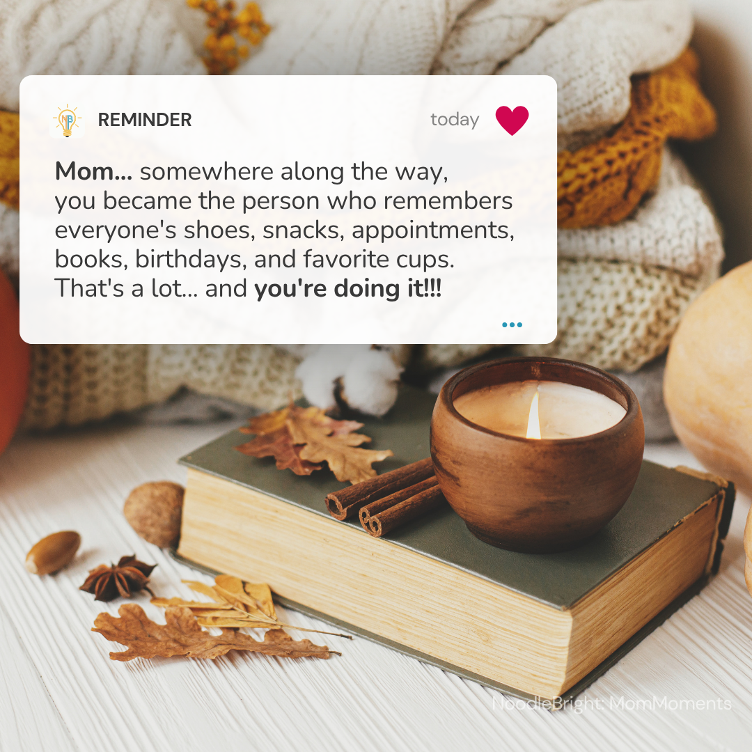 A digital card overlay with a warm reminder message for a mother, set against a cozy flat-lay background of an open book, cinnamon sticks, star anise, a wooden candle holder, and autumn leaves. Reminder says, "Mom... somewhere along the way, you became the person who remembers everyone's shoes, snacks, appointments, books, birthdays, and favorite cups. That's a lot... and you're doing it!!!"